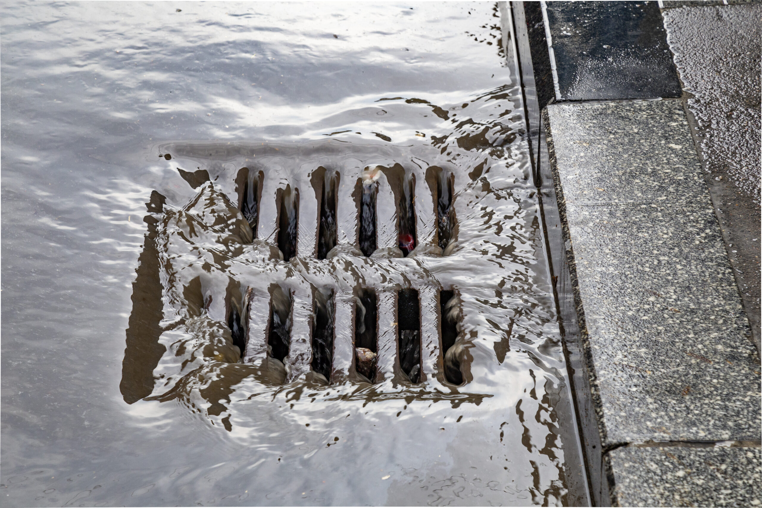 Water rushing into stormwater drain.