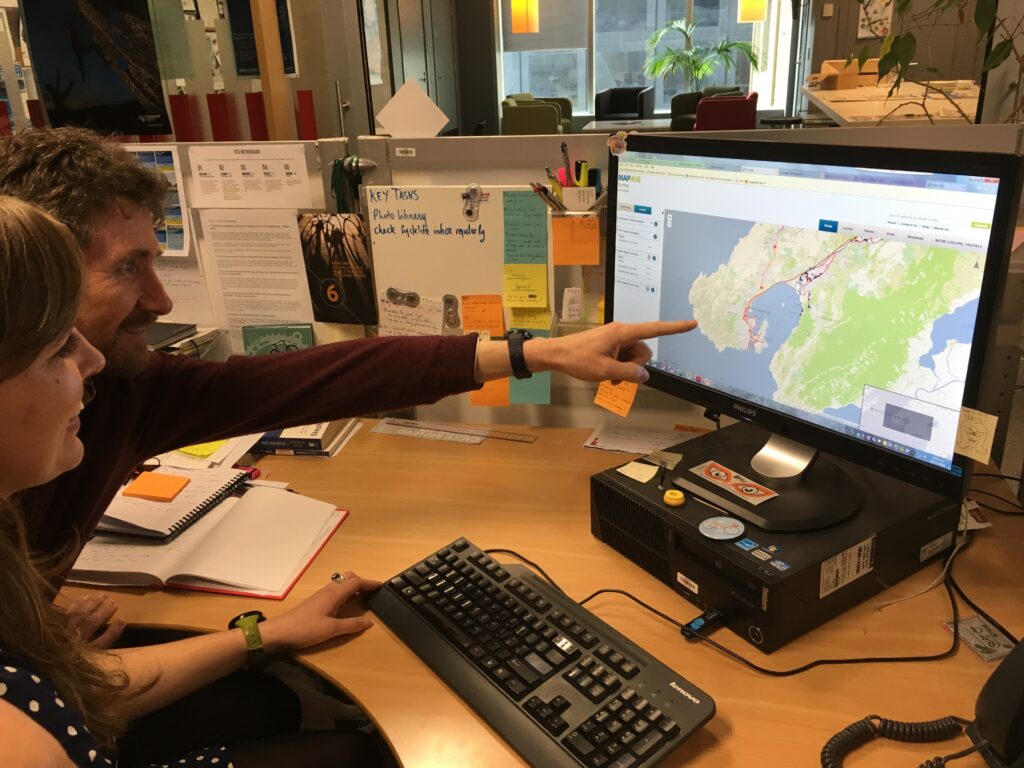 Two people looking at an ArcGIS map displayed on a desktop computer.