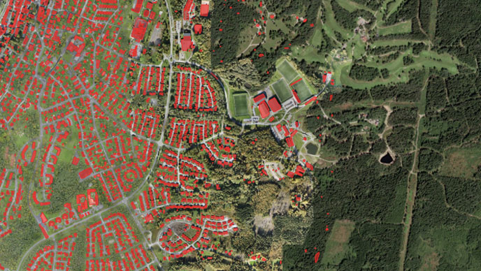 Aerial image with red building outlines over residential and forested areas.
