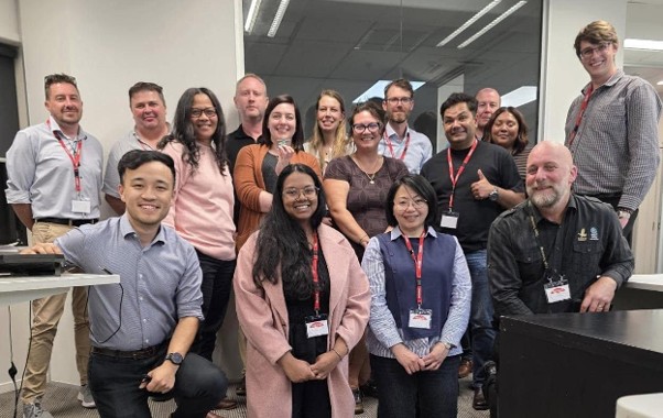 A group of professionals wearing matching lanyards smiling for a group photo.